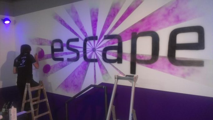 Escape-Logo München Logo einer Discothek im Eingangsbereich mit UV Farben, welche erst im Schwarzlicht leuchten