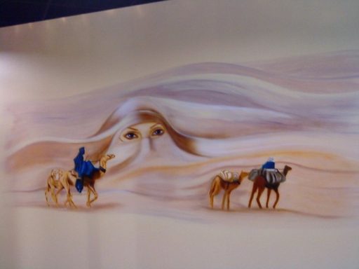 Wüstengeist Künstlerische Darstellung einer Kamelkarawane in der Wüste , mit einem Frauengesicht welches in einer Sanddüne erscheint