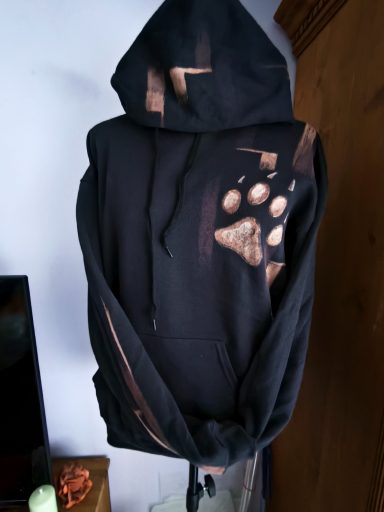 Wolfgeheul im Waschsalon Hoodie mit Wolfskopf auf der Rückseite, vorne eine Wolfspfote. Graphischer Hintergrund, der sich auf dem Ärmel und der Kapuze wiederholt