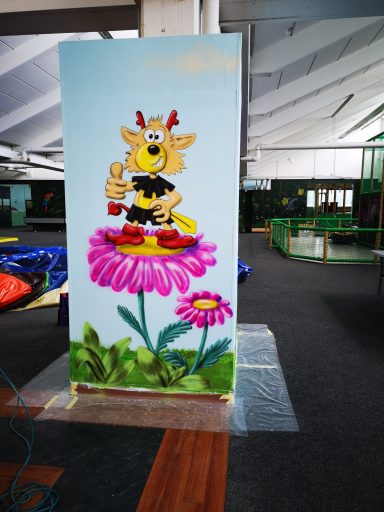 Maskottchen auf der Blume Bemalte Wand des Indoor Spielplatzes Wölpi. Maskottchen auf der Blume