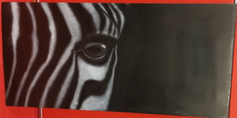 Zebra Messeauftritt Livebemalung:
Teilansicht eines Zebrakopfes auf einem Holzgrund